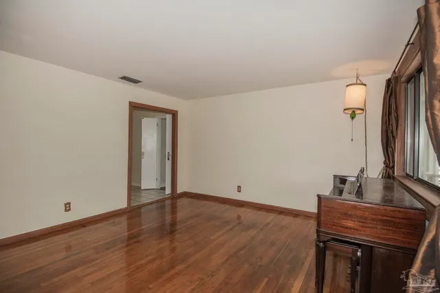 a view of an empty room with wooden floor