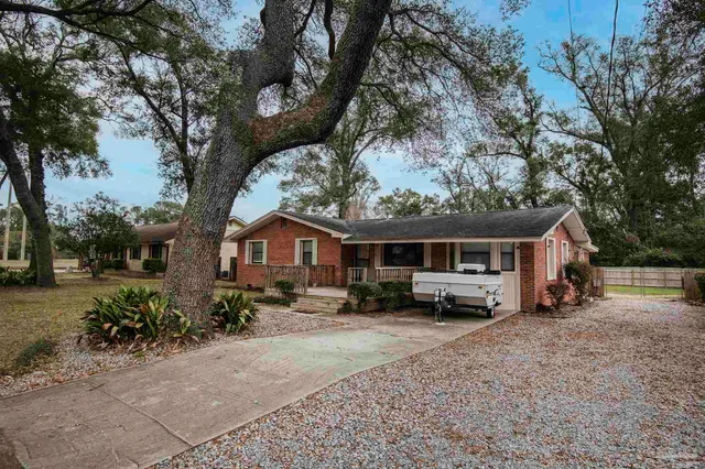 a view of a house with a large tree in front