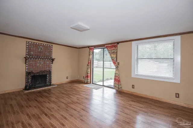 wooden floor fireplace and windows in an empty room