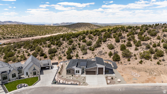 2862 South Mountain Rnch Road Cedar City, UT 84720 - Photo 64 of 64 Modern residential architecture featuring a dark gray roof, light-colored stone accents, and an attached two-car garage