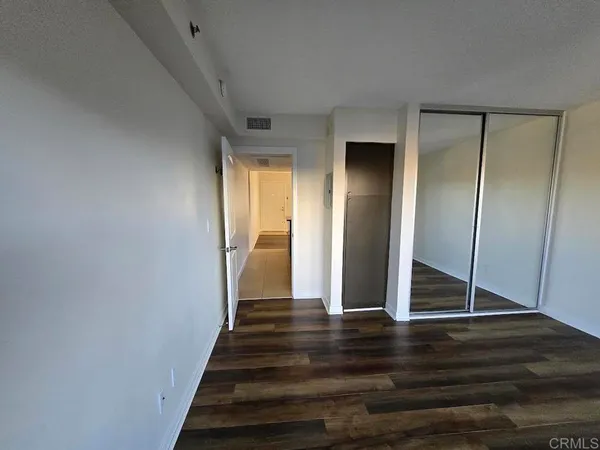 a view of a hallway with wooden floor and entryway