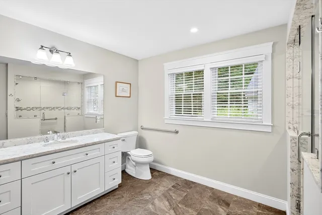 a spacious bathroom with double vanity a window a double and a shower