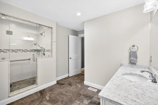 a bathroom with a granite countertop sink a shower and a mirror