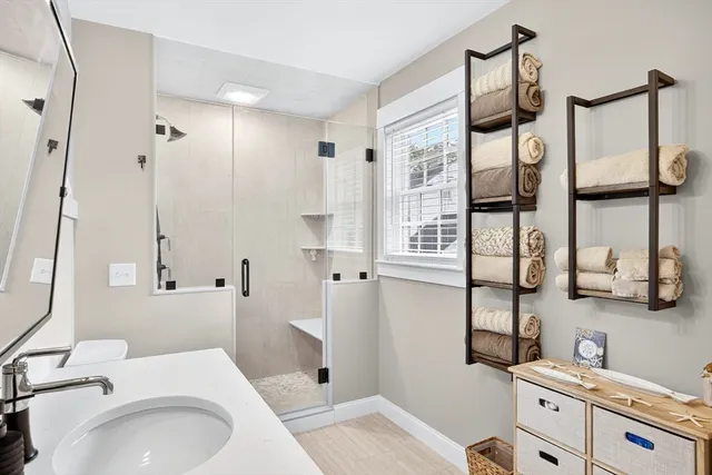 a bathroom with a sink a toilet and shower