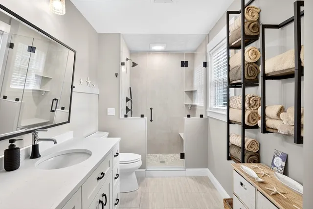 a bathroom with a sink a toilet and shower