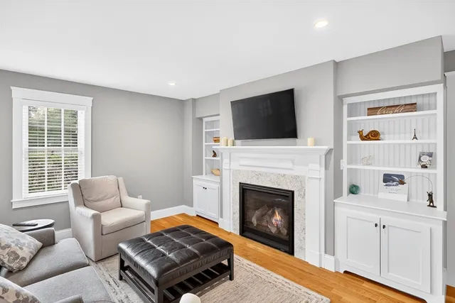 a living room with furniture a flat screen tv and a fireplace