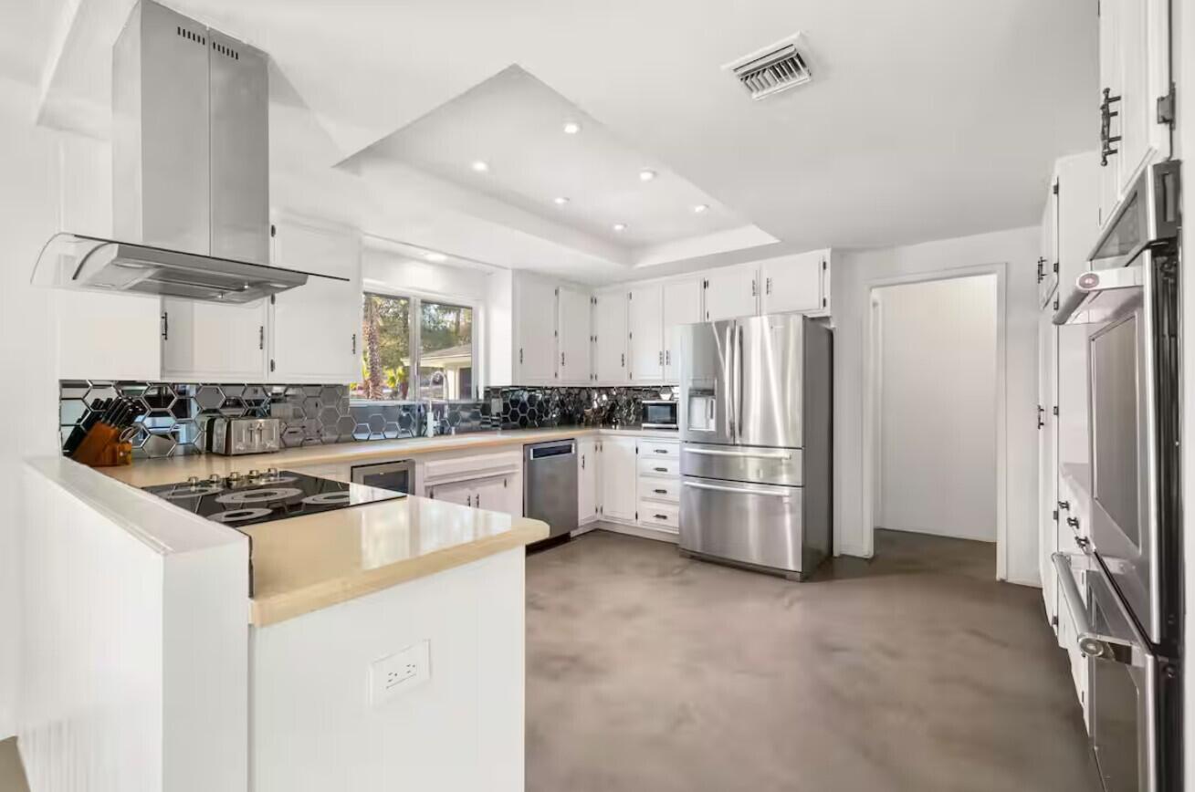 6451 Red Bluff Avenue Yucca Valley, CA 92284 - Photo 19 of 71 a kitchen with stainless steel appliances a refrigerator a stove a sink and white cabinets