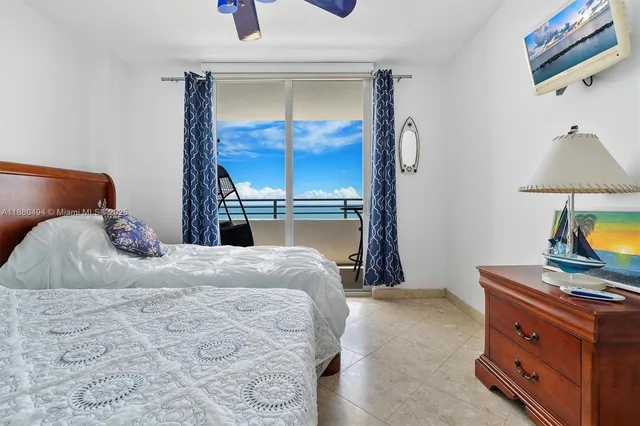 a bedroom with a bed and a lamp on dresser