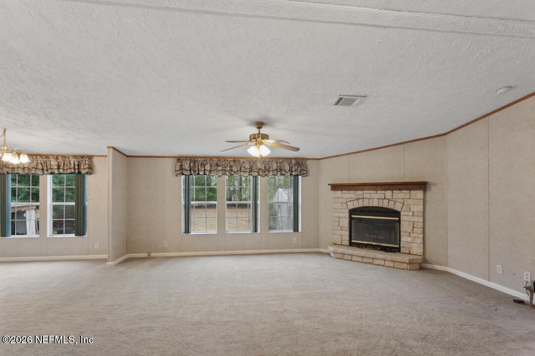 5316 Carter Spencer Road Middleburg, FL 32068 - Photo 7 of 19 an empty room with fireplace and windows