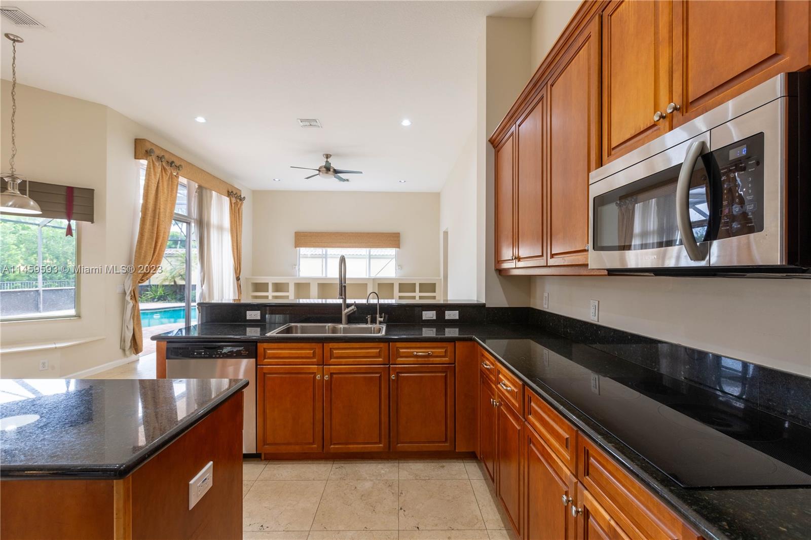 Sunset Lakes Miramar, FL 33029 - Photo 33 of 51 a kitchen with stainless steel appliances granite countertop a sink a stove top oven a counter space and cabinets