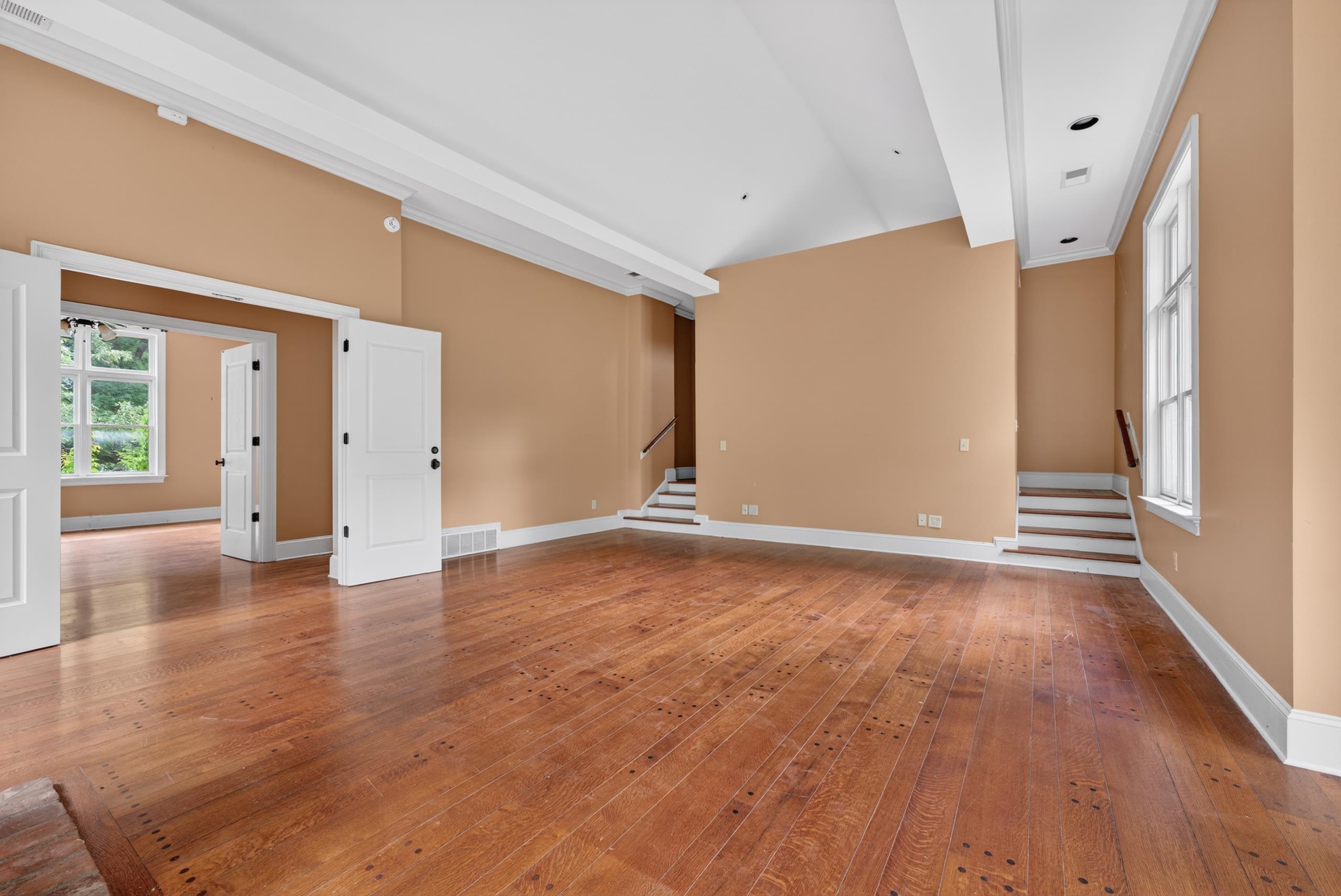 530 West Raines Road Memphis, TN 38109 - Photo 34 of 38 Spacious interior featuring wood-finish flooring, two sets of double doors, a large framed window, and a staircase with a wood handrail