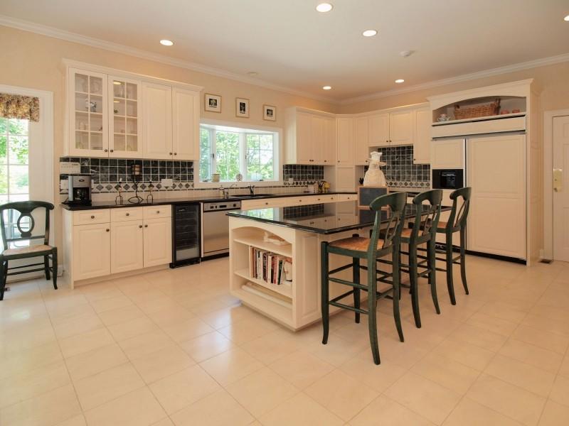 284 Hawks Hill Road New Canaan, CT 06840 - Photo 5 of 23 a kitchen with stainless steel appliances kitchen island granite countertop a table chairs sink and cabinets