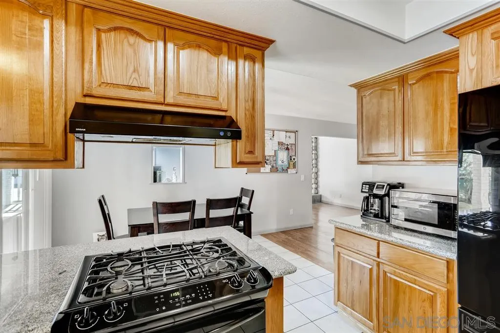 13131 Chrissy Way Lakeside, CA 92040 - Photo 10 of 25 a kitchen with a stove a sink and wooden cabinets