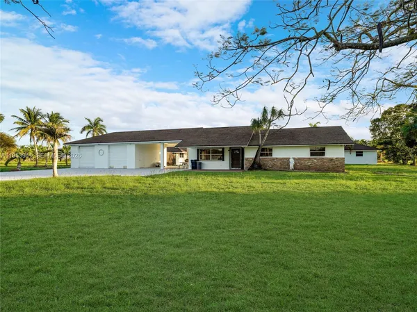 a front view of house with a garden