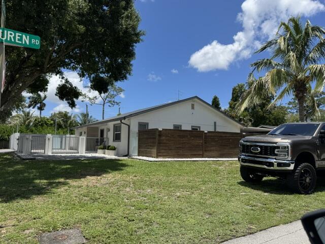 15276 Harrison Road Delray Beach, FL 33484 - Photo 72 of 75 a front view of a house with a yard and garage