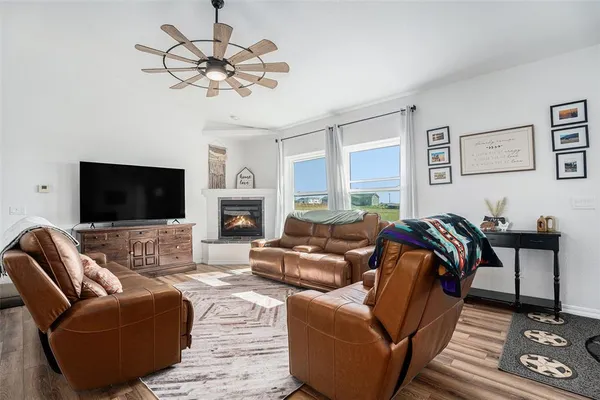 a living room with furniture kitchen view and a chandelier