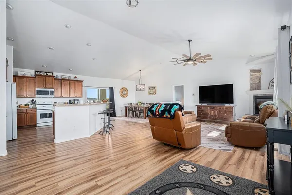 a kitchen with stainless steel appliances granite countertop a stove top oven a sink dishwasher and a refrigerator with wooden cabinets