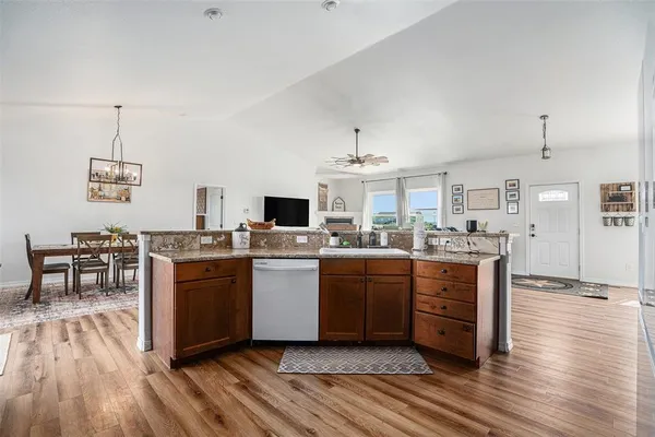 a view of a dining room and kitchen with furniture wooden floor and a rug