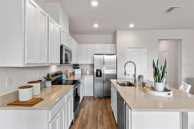 a kitchen with refrigerator a stove and cabinets
