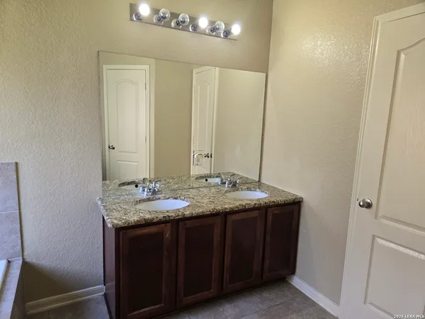 a bathroom with a granite countertop sink and a mirror