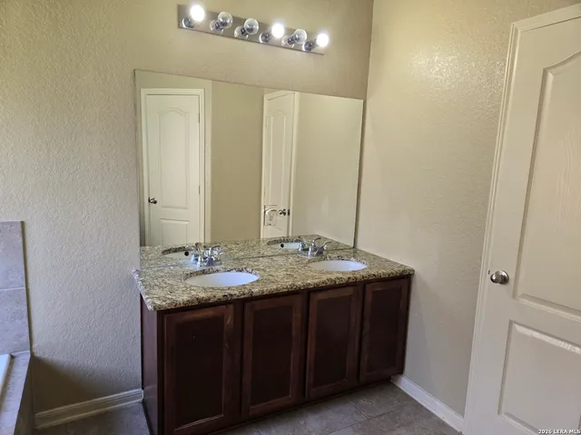 a bathroom with a granite countertop sink and a mirror