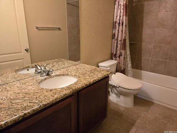 a bathroom with a granite countertop sink toilet and shower