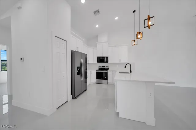 a large white kitchen with stainless steel appliances