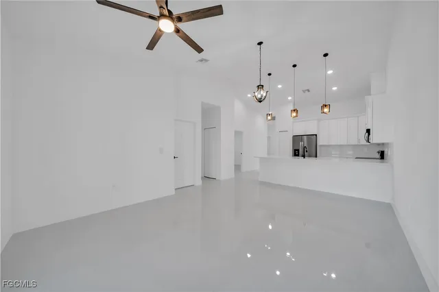 a view of kitchen with kitchen island stainless steel appliances a sink a refrigerator and a stove