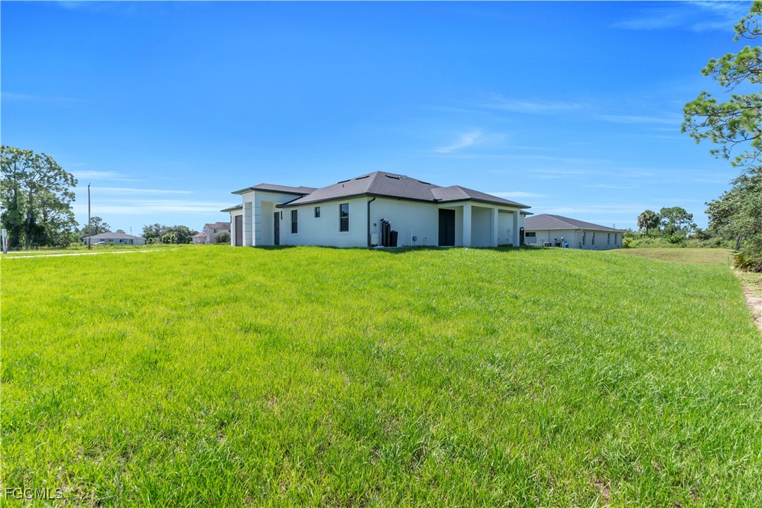 1110 Eisenhower Boulevard Lehigh Acres, FL 33974 - Photo 30 of 35 a view of a house with a yard