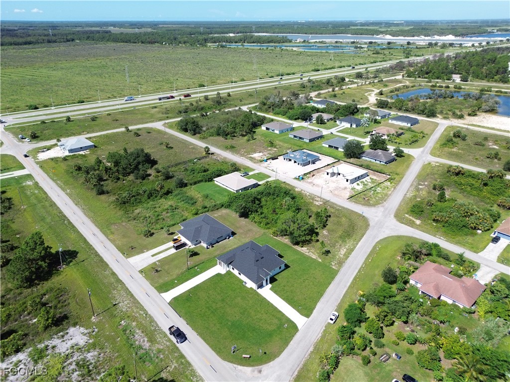 1110 Eisenhower Boulevard Lehigh Acres, FL 33974 - Photo 33 of 35 an aerial view of residential houses with outdoor space and lake view