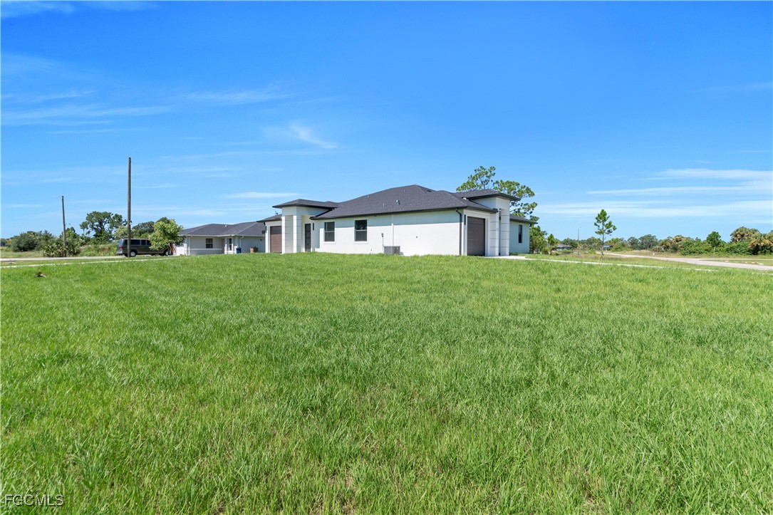1110 Eisenhower Boulevard Lehigh Acres, FL 33974 - Photo 7 of 35 a view of a house with a big yard