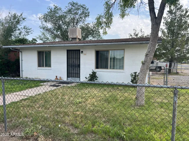 a view of a house with backyard and a tree