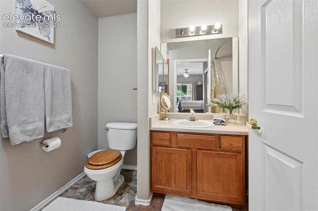 3715 Riviera Grove, Unit 101 Colorado Springs, CO 80922 - Photo 29 of 36 Bathroom featuring a single vanity with wood cabinetry, a white countertop, and an integrated sink
