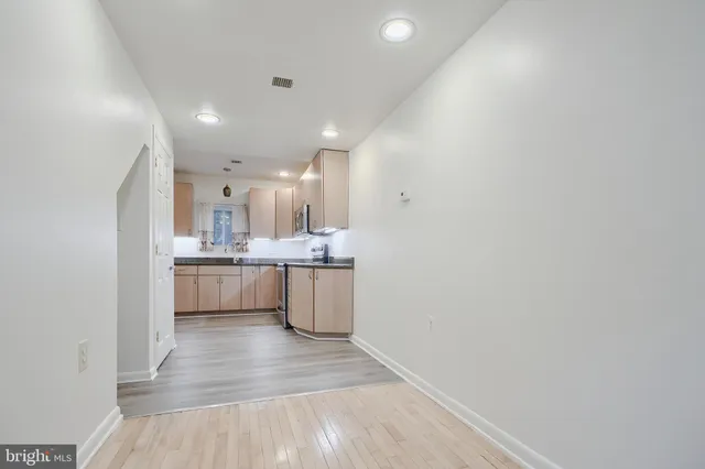 a kitchen with a sink cabinets and wooden floor