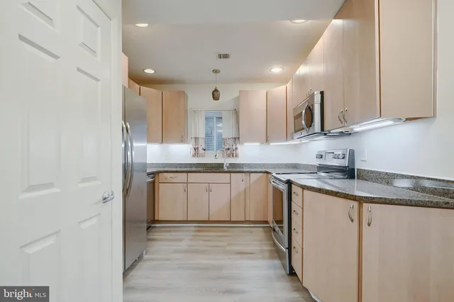 a kitchen with stainless steel appliances granite countertop a sink and cabinets