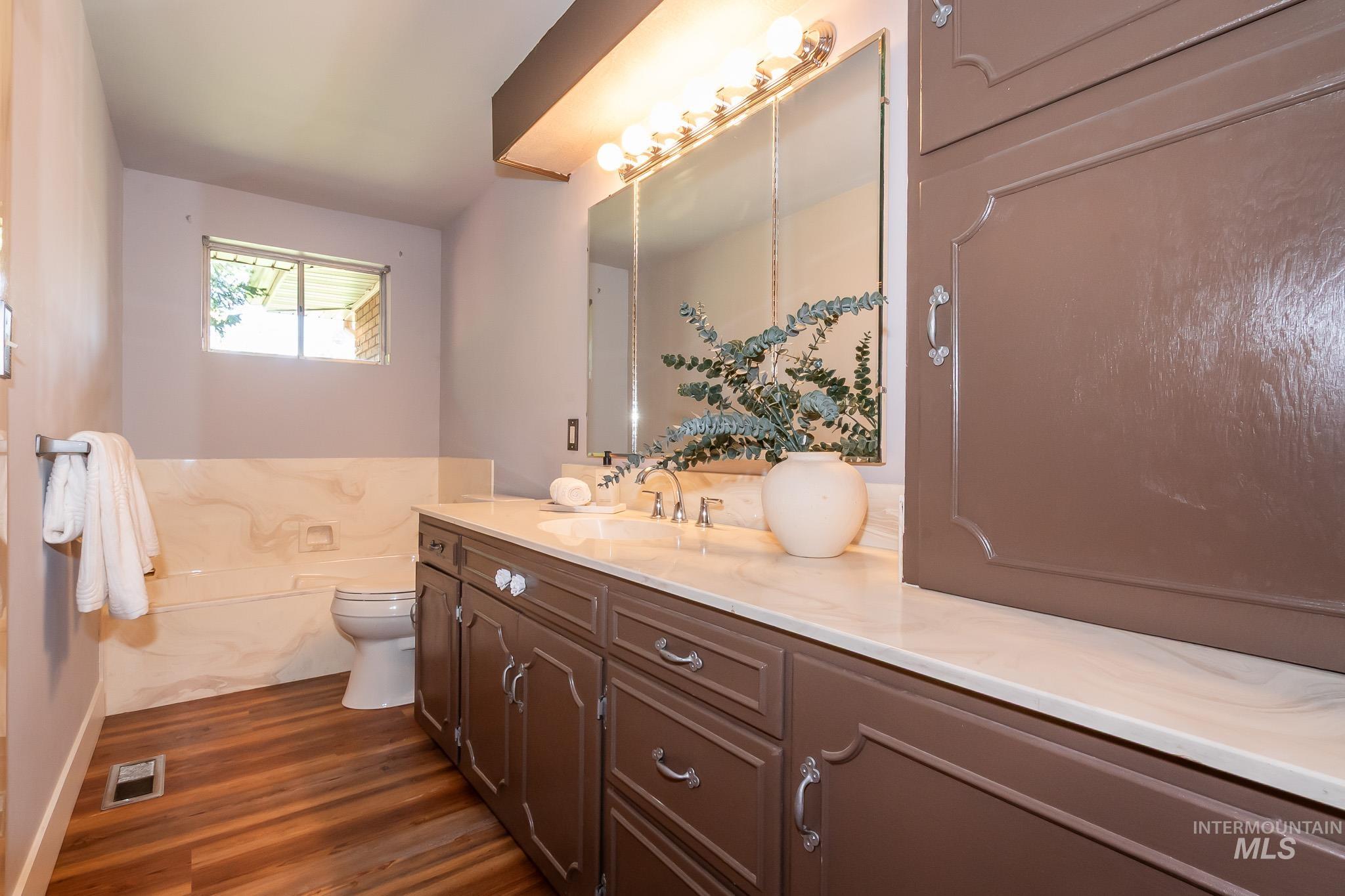 3706 West Clement Road Boise, ID 83704 - Photo 22 of 36 Wood-finish flooring with a vanity featuring a light-colored countertop and integrated sink