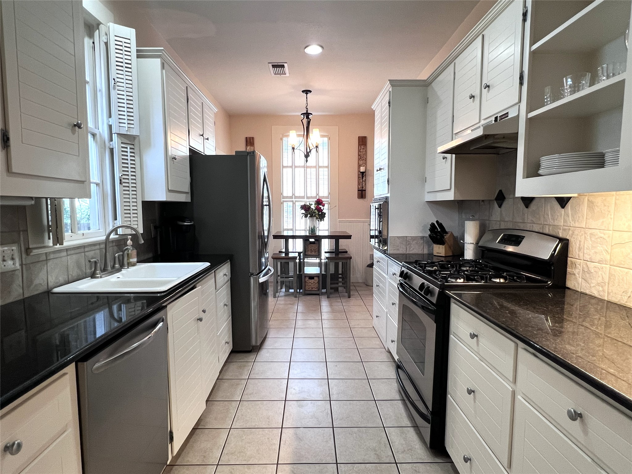 606 Sycamore Street Brenham, TX 77833 - Photo 8 of 27 a kitchen with stainless steel appliances granite countertop a stove a sink and a refrigerator