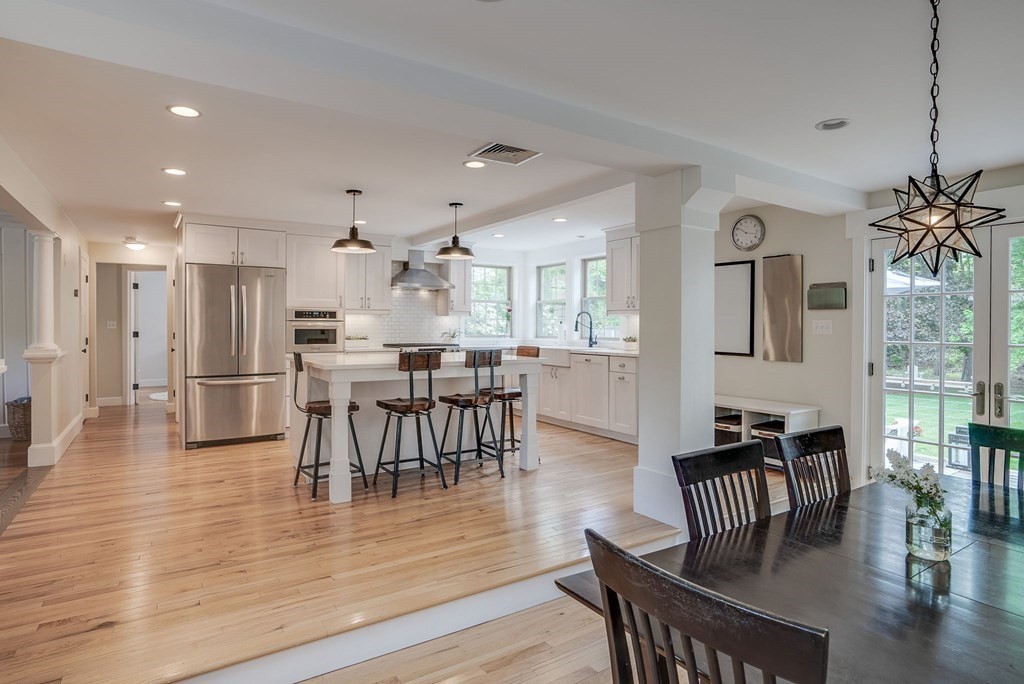 290 Concord Road Bedford, MA 01730 - Photo 6 of 41 a view of a dining room and livingroom with furniture wooden floor a chandelier