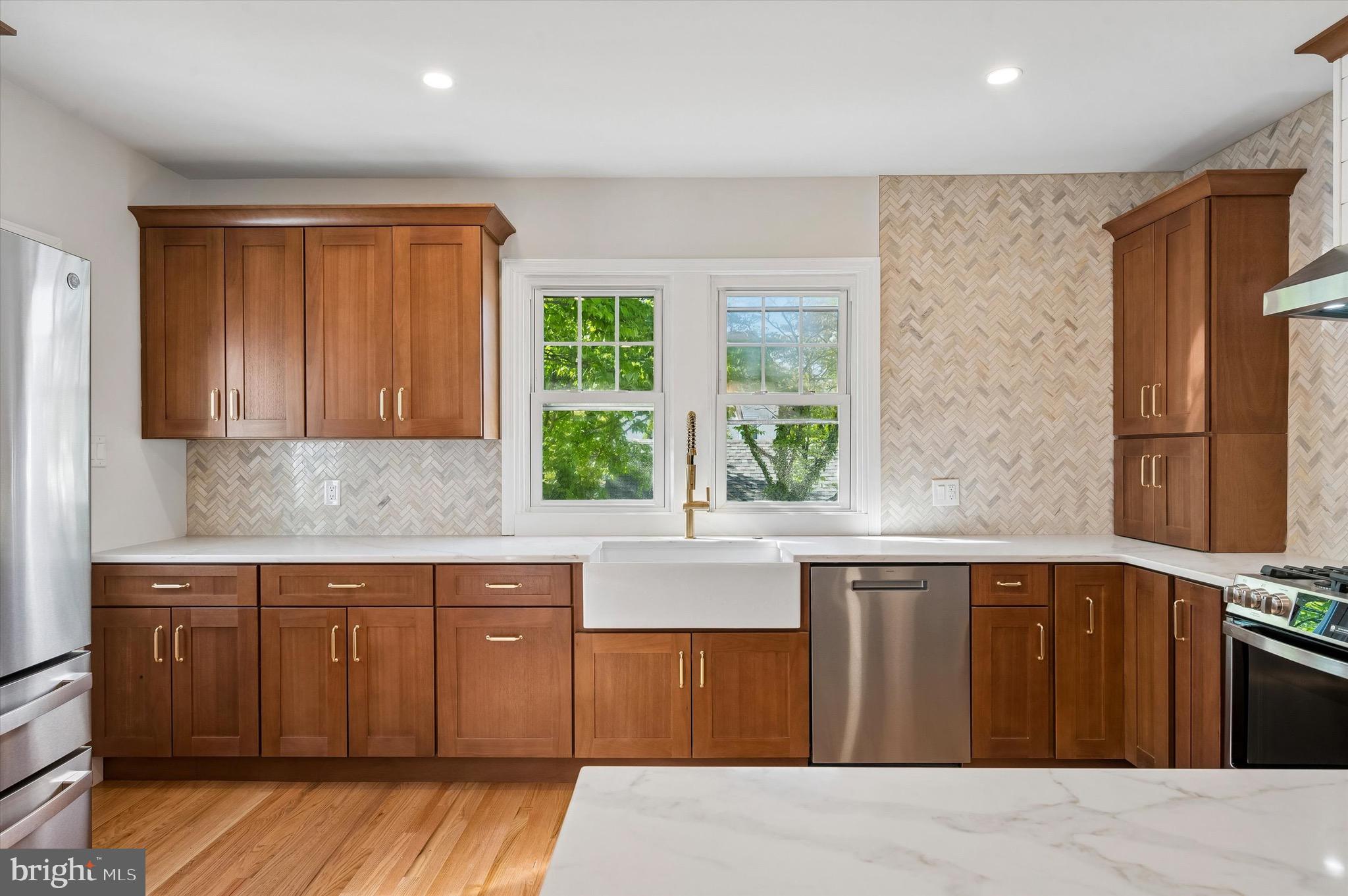 100 Yale Road Havertown, PA 19083 - Photo 12 of 35 a kitchen with stainless steel appliances granite countertop a stove a sink dishwasher and wooden cabinets with wooden floor