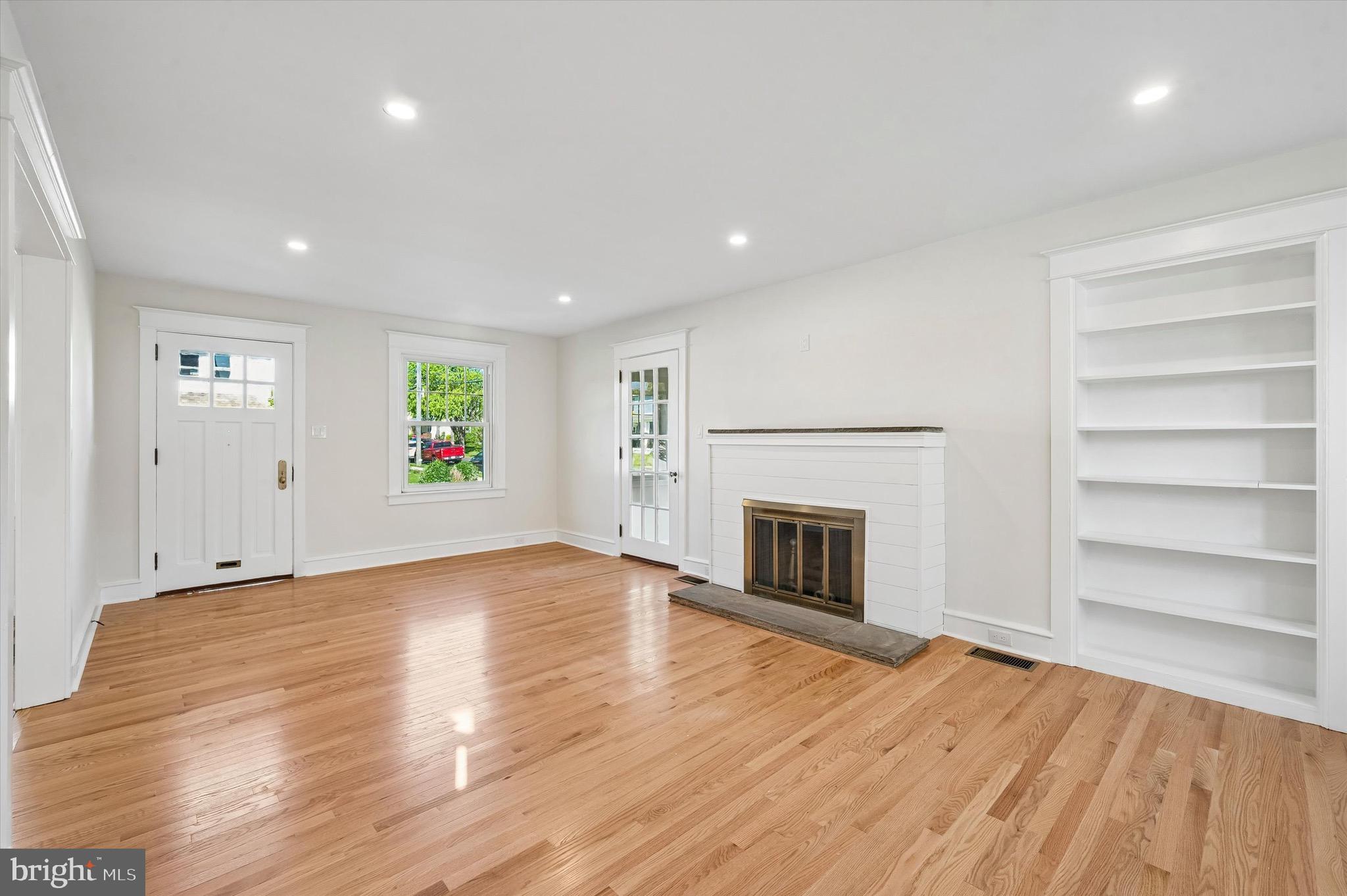 100 Yale Road Havertown, PA 19083 - Photo 7 of 35 an empty room with wooden floor fireplace and windows