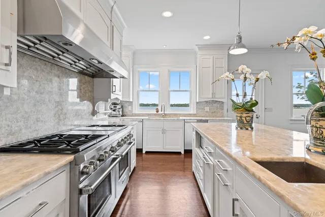 a kitchen with kitchen island stainless steel appliances a sink stove and cabinets