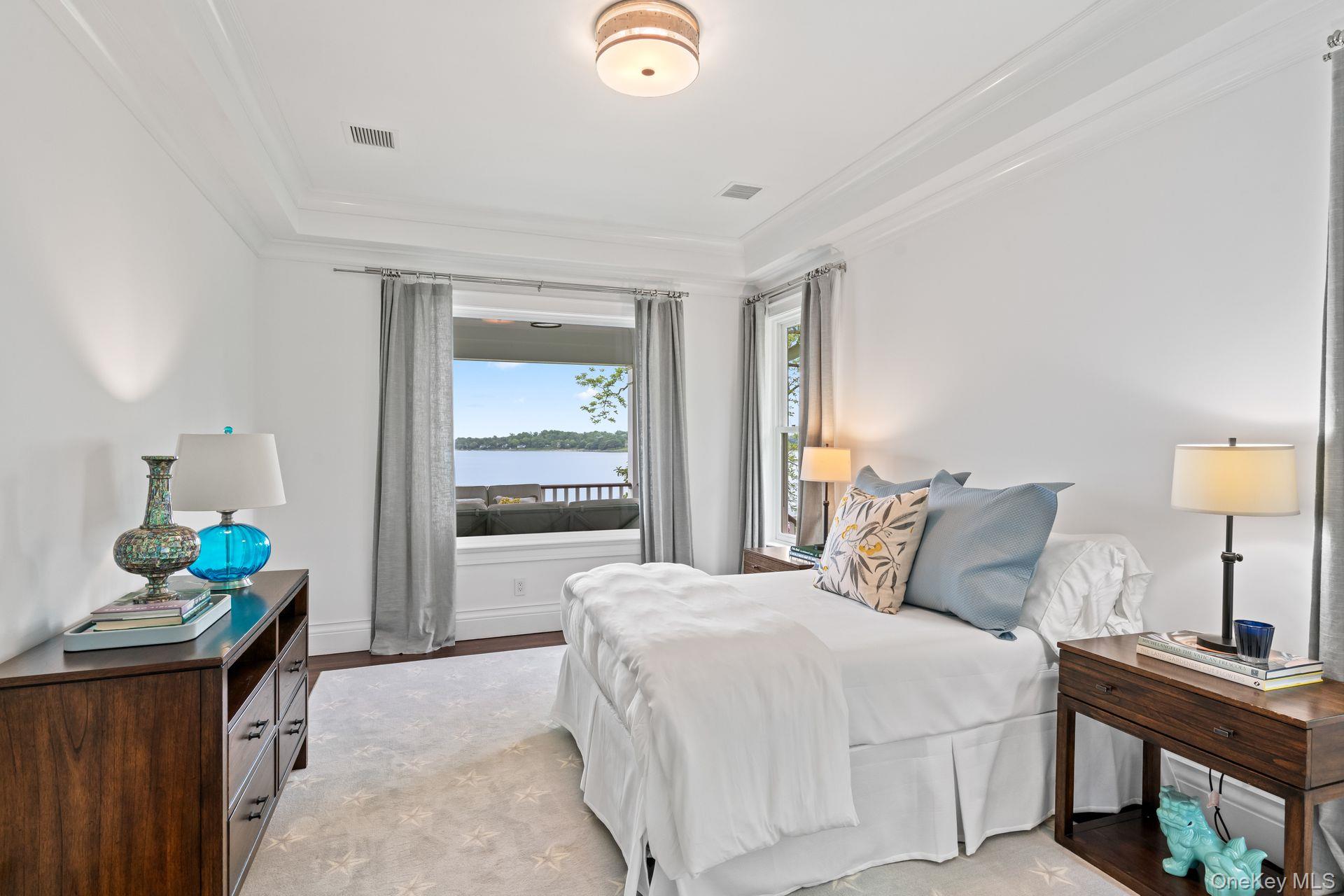 998 West Shore Road Mill Neck, NY 11765 - Photo 16 of 36 a bedroom with a bed and wooden floor