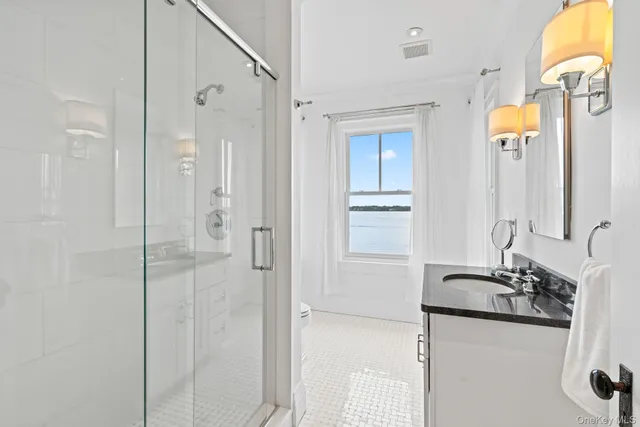 a bathroom with a granite countertop shower sink and mirror