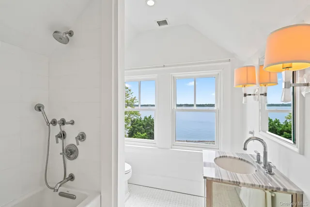 a bathroom with a granite countertop sink and a shower