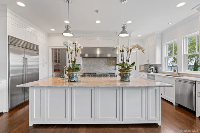 a kitchen with kitchen island granite countertop a stove a sink a center island and wooden floor