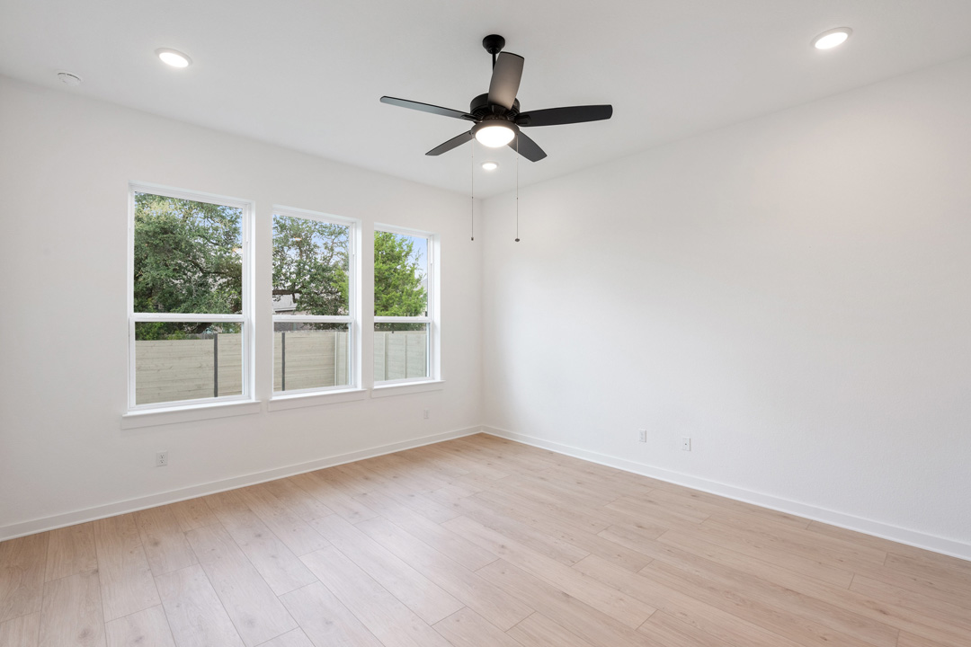 1114 Blue Moon Drive Georgetown, TX 78628 - Photo 21 of 39 an empty room with wooden floor fan and windows