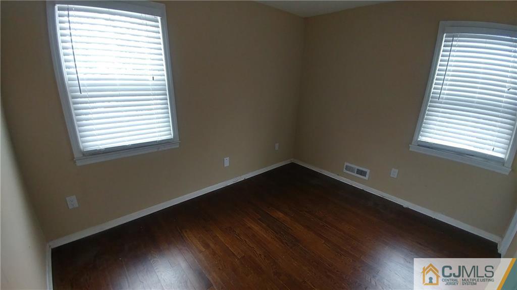 1019 Main Street Fords, NJ 08863 - Photo 11 of 13 a view of an empty room with wooden floor and a window