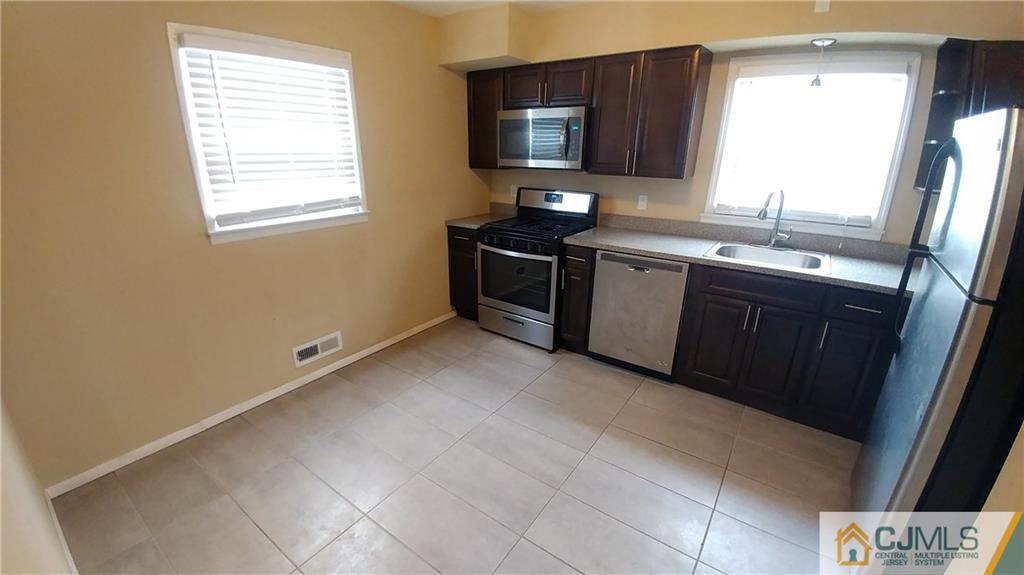 1019 Main Street Fords, NJ 08863 - Photo 13 of 13 a kitchen with a stove a sink and a microwave