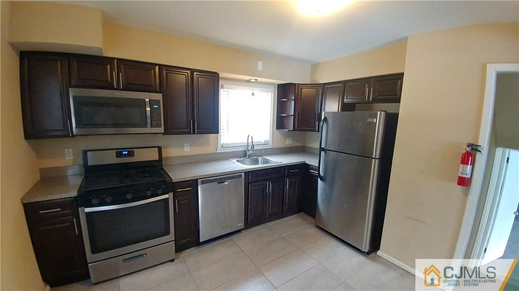 1019 Main Street Fords, NJ 08863 - Photo 3 of 13 a kitchen with a refrigerator stove and microwave