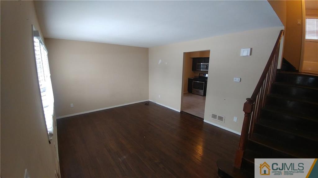 1019 Main Street Fords, NJ 08863 - Photo 4 of 13 an empty room with wooden floor and windows
